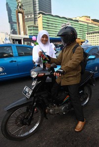 Bunga mawar dari kertas krep tersebut dibagikan kepada para pengguna jalan.