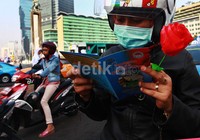 Seorang pengendara sepeda motor tampak membaca selembaran anti narkoba yang dibagikan secara gratis.
