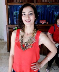 Atiqah tampil santai dibalut tank top merah yang dipadukan dengan aksesoris kalung berbentuk kupu-kupu.