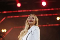Interaksi positif dari penonton membuat Rita Ora tersenyum manis di atas panggung. REUTERS/Darrin Zammit Lupi.     
