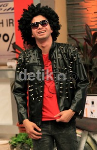 Raffi memadukan jaket kulitnya itu dengan kaus merah dan celana hitam.
