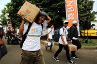 Para pemudik membawa barang-barang khas mudik, seperti kardus dan tas besar.