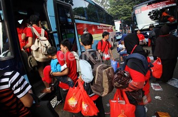 Para pemudik memasuki bus yang akan mengantarkan ke kempung halaman.