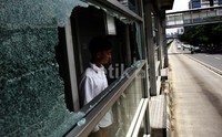 Seorang penumpang sedang memperhatikan kaca Halte TransJakarata yang pecah akibat ditembak. Lamhot Aritonang/detikFoto.