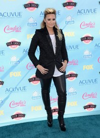 Demi Lovato bergaya rock style, dengan celana panjang hitam dan blazer hitam. Jason Merritt/Getty Images/AFP.