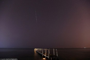 Lintasan meteor yang panjang menampakkan diri di sebuah pantai di Yunani. (kredit foto: EPA)