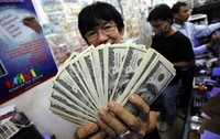 Seorang pedagang valuta asing di bilangan ITC Kuningan, Jakarta Selatan, menunjukkan uang hasil transaksi.