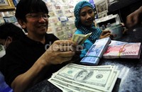 Salah seorang pedagang valuta Asing di ITC Kuningan, melayani transaksi penukaran beragam mata uang.
