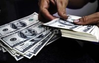 Seorang pedagang valuta asing di bilangan ITC Kuningan, Jakarta Selatan, sedang menghitung dolar hasil transaksi.