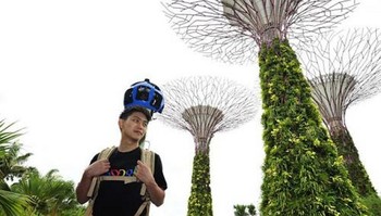Google mempekerjakan karyawannya atau relawan untuk diseleksi merekam suasana sekitar dengan kamera canggih yang dibawa dengan tas berjuluk Trekker. Tampak seorang pria merekam keadaan sekitar Marina Bay, Singapura. (kredit foto: Strait Times)