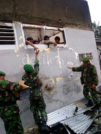 Tentara memberikan minuman kepada napi yang kehausan karena tak ada air minum di dalam.