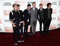 Ini dia sang sutradara Morgan Spurlock dengan setelan jas abu-abu, sempat berfoto bersama para personel One Direction. Ian Gavan/Getty Images.     