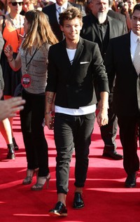 Louis Tomlinson terlihat casual dengan blazer dan tshirt putih dipadu dengan celana jeans dan sepatu hitam. Tim P. Whitby/Getty Images.