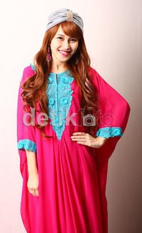 Ayu terlihat manis dalam balutan kaftan shocking pink dengan aksen bordir biru muda.