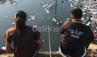 Meski banyak sampah, mereka tetap asyik memancing.