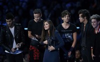 Selena Gomez saat menerima penghargaan di atas panggung bersama One Direction. REUTERS/Eric Thayer.