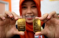 Seorang customer service BNI Syariah cabang Benhil Jakarta Pusat menunjukkan emas batangan Logam Mulia 100 gram akhir pekan lalu.