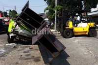 Alat berat mengevakuasi muatan truk.