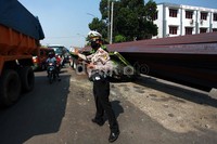 Seorang polisi berusaha mengurai kemacetan.