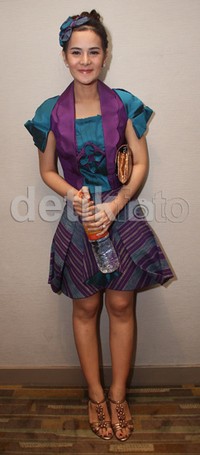 Ia memadukan dress-nya itu dengan heels gold.