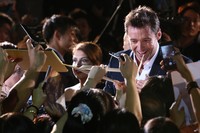 Hugh Jackman langsung disambut oleh kerumunan penggemar yang ingin meminta tanda tangan. Ken Ishii/Getty Images.