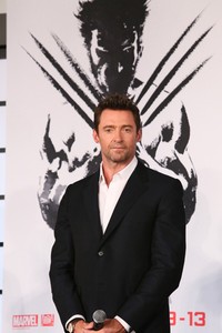    Berdiri di depan poster bergambar Wolverine dengan cakar garangnya, Hugh Jackman terlihat gagah. Ken Ishii/Getty Images.