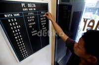 Seorang pekerja tampak sedang mengganti papan informasi harga jual beli mata uang asing di tempat penukaran uang asing (money changger) di Jakarta, Kamis (29/8/2013).