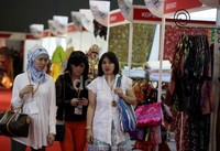 Tiga orang pengunjung berkeliling untuk melihat pameran.