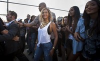 Di kesempatan tersebut, Beyonce tampil mengenakan tank top putih yang dipadu dengan celana jeans ketat dan perhiasan emas yang berkesan glamor. REUTERS/Carlo Allegri.