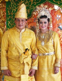 Mereka terlihat serasi dalam balutan baju adat berwarna kuning keemasan.