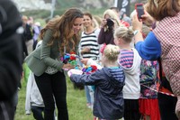 Kate Middleton terlihat menerima sebuah karangan bunga dan kartu ucapan dari anak-anak setempat yang dibuat khusus untuk Pangeran Goerge. Paul Lewis/Getty Images.