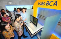 Direktur BCA Armand W. Hartono melakukan transaksi perbankan dengan mengisi kartu flazz BCA dan mencoba layanan halo BCA serta layanan internet bangking BCA seusai membuka Electronic Banking Center. (dok BCA).