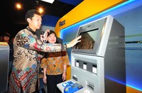Direktur BCA Armand W. Hartono melakukan transaksi dengan didampingi Kepala Divisi Strategi & Pengembangan Operasi Layanan BCA Lilik Winarni. (dok BCA).