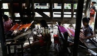     Dengan alat sederhana beberapa orang perempuan Desa Huta Raja,  menenun ulos dikolong rumahnya memenuhi pesanan.     