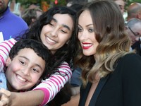 Olivia Wilde terlihat berser-seri saat berfoto bersama fans. Chris Jackson/Getty Images.