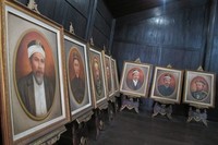 Di bagian tengah bangunan terdapat lukisan raja-raja terdahulu. Ada pula sepasang patung yang mengenakan pakaian khas daerah setempat (Vita/detikTravel)