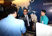 Direktur Layanan Faik Fahmi bersama seorang petugas memberikan salah satu pelanggan souvenir dalam rangka memperingati Hari Pelanggan Nasional.