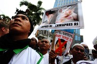 Pendemo juga membawa poster bergambar wajah Hary Tanoe yang mengenakan bikini.