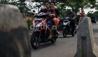 Para pelajar mengendarai sepeda motor tanpa menggunakan helm di jalan inspeksi Kanal Banjir Timur, Cipinang, Jakarta Timur, Selasa (10/09/2013).
