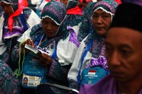 Beberapa jamaah haji mempelajari buku panduan sebelum diberangkatkan.