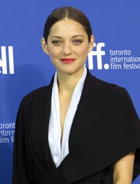 Menampilkan detail berupa kerah berwarna biru muda yang unik dibalut dengan desain kimono asimetris, Marion Cotillard tampil sederhana tapi manis. REUTERS/Fred Thornhill.     