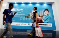 Seorang pengunjung melintas di depan banner Garuda Travel Fair di lokasi.