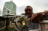     Petugas dengan menggunakan alat bernama campbell stokes mengecek lamanya penyinaran matahari.
