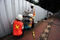 Sejumlah pekerja memasang seng pembatas di Jl Sudirman, Jakarta.