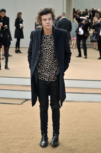 Harry dibalut blouse motif leopard dan dipadu coat, celana, dan sepatu hitam. Gareth Cattermole/Getty Images for Burberry.