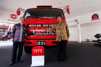 Managing Director UD Truck Indonesia Pierre Jean Verge Salamon bersama CEO PT Astra Internasional UD Truck Sales Operation berpose di depan truk pertama keluaran 1975.