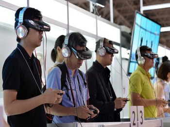 Pengunjung sedang menjajal head mount display (HMD) Sony HMZ-T3. (Kredit foto: Getty Images)