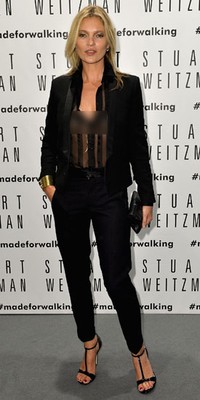     Kate Moss tampil dengan setelan serba hitam yang seksi mengenakan blouse transparan dari Saint Laurent dengan luaran tuxedo. Tullio M. Puglia/Getty Images.