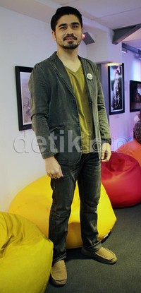 Ia tampil casual dalam balutan kaus hijau yang dipadu dengan blazer dan celana warna senada.