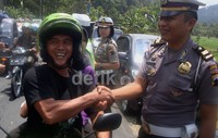 Seorang pemotor tampak senang setelah mendapatkan helm gratis.